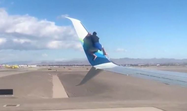 uçağın kanadına tırmandı